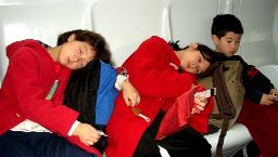 Tired children on bus to plane at Charles de Gaulle airport