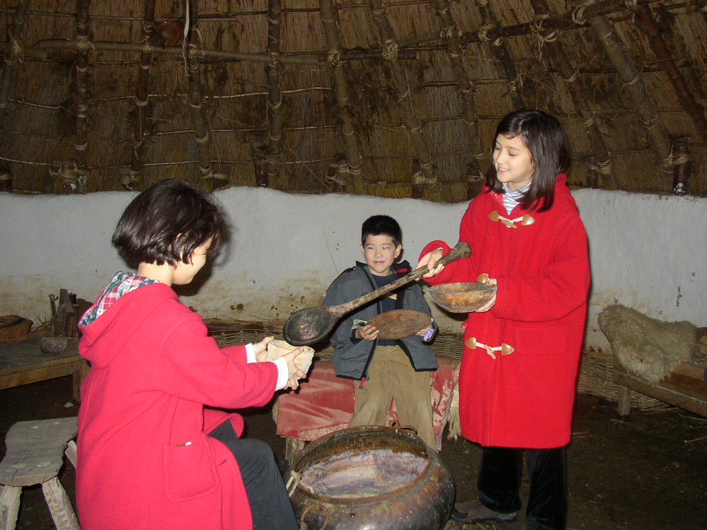 Abigail serving dinner in a hut at the Heritage Park.